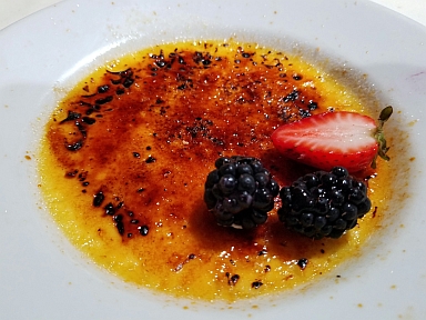 A photograph of a crème brûlèe from Augusto's of Madison